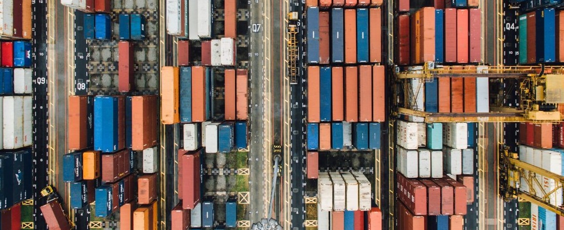 Contêineres empilhados representando a disrupção das commodities e o impacto na logística global e no comércio exterior